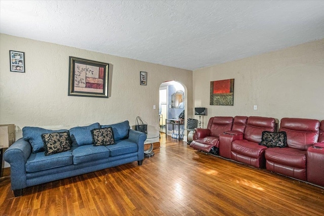 232 Courthouse Rd, Franklin Square, NY 11010 - living room featuring a textured ceiling, wood finished floors, a textured wall, and arched walkways