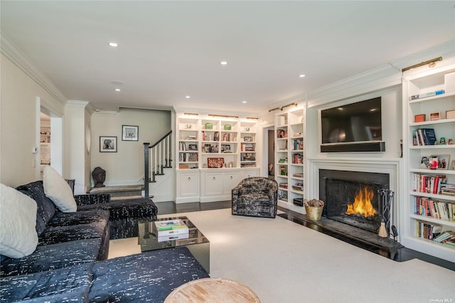 living area featuring stairway, crown molding, a warm lit fireplace, built in shelves, and recessed lighting