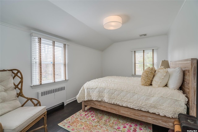 bedroom featuring radiator heating unit, vaulted ceiling, visible vents, baseboards, and dark wood-style flooring