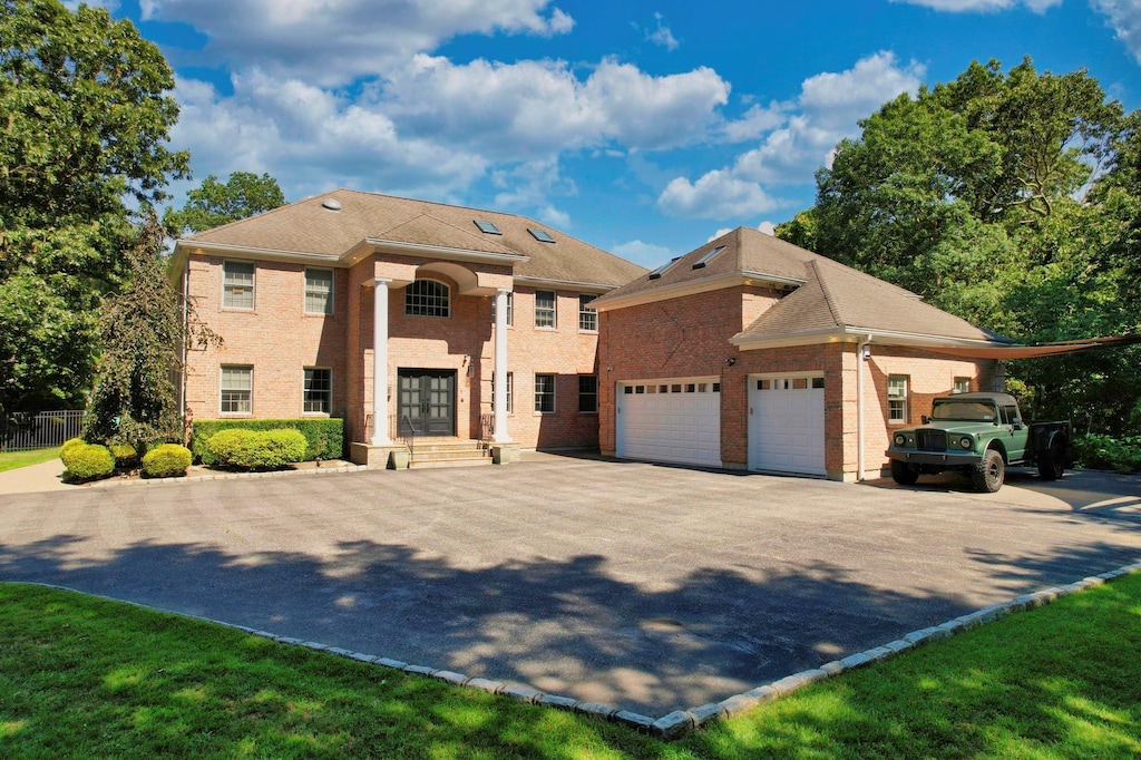 view of front of home with brick siding, an attached garage, and driveway