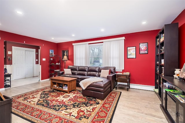 living area featuring a baseboard heating unit, baseboards, wood finished floors, and recessed lighting