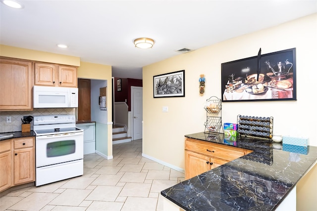 kitchen featuring dark stone countertops, baseboards, recessed lighting, backsplash, and white appliances