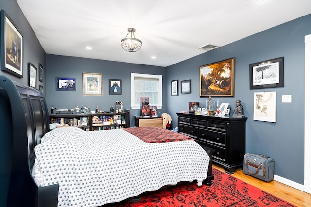 bedroom featuring baseboards, wood finished floors, visible vents, and recessed lighting