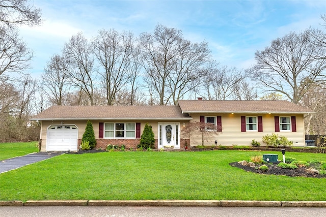 ranch-style home with a garage, driveway, a chimney, and a front yard