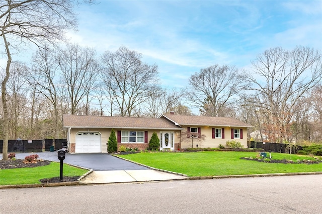 view of front of house with a chimney, aphalt driveway, an attached garage, fence, and a front yard