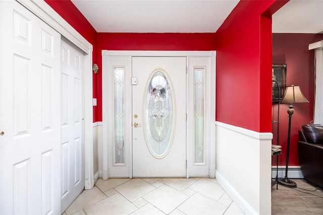 tiled entryway with baseboard heating and baseboards