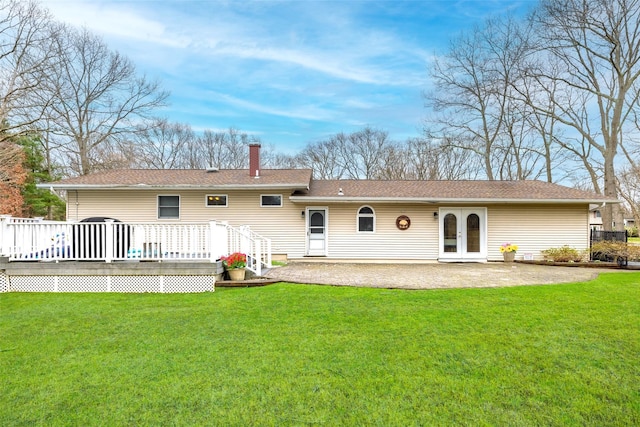 back of house featuring french doors, a chimney, a patio area, a deck, and a yard