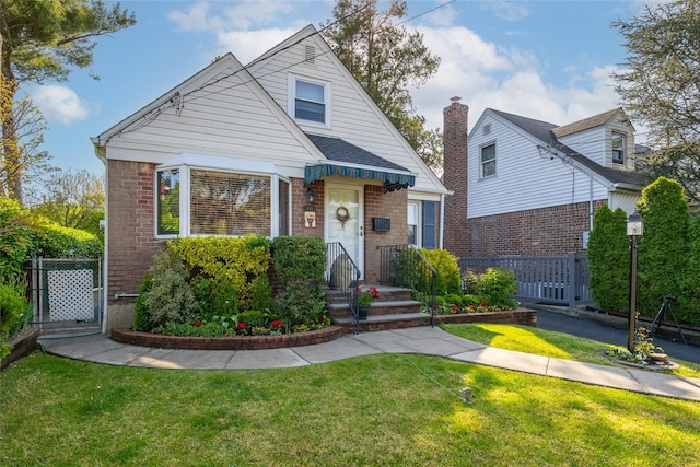 bungalow-style home featuring brick siding, a gate, and a chimney