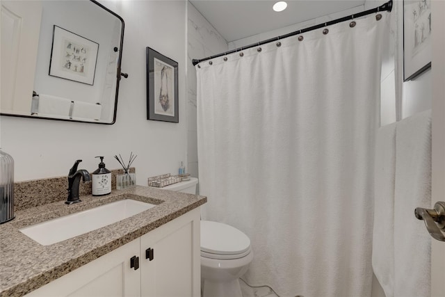 bathroom featuring toilet, vanity, and curtained shower