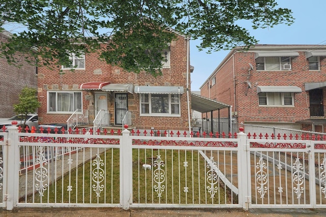 view of front of home with brick siding, a front lawn, and a fenced front yard