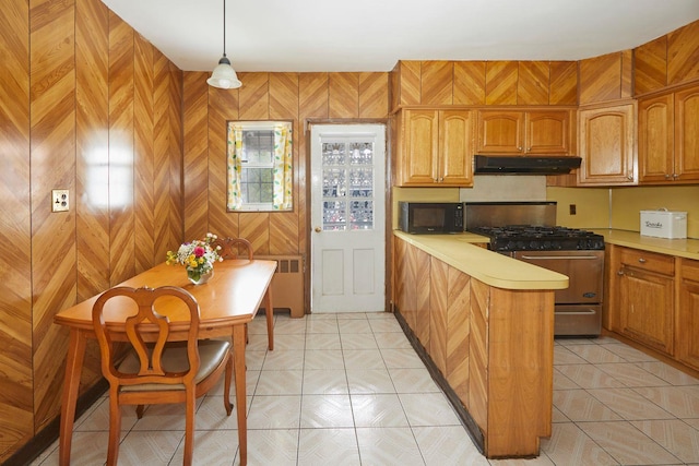 kitchen with stainless steel range with gas cooktop, black microwave, a peninsula, under cabinet range hood, and light countertops