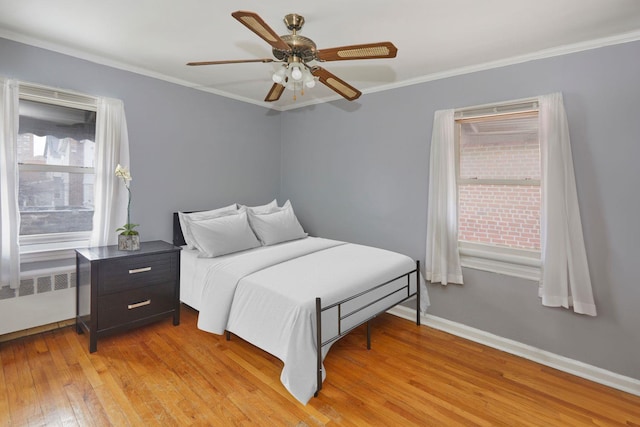 bedroom featuring baseboards, ornamental molding, a ceiling fan, radiator heating unit, and light wood finished floors