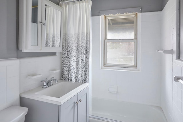 bathroom featuring shower / bath combination with curtain, vanity, tile walls, and toilet