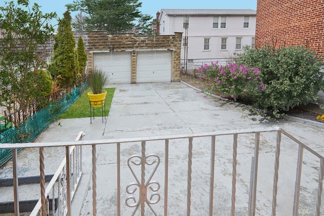 exterior space featuring fence, a garage, and concrete driveway