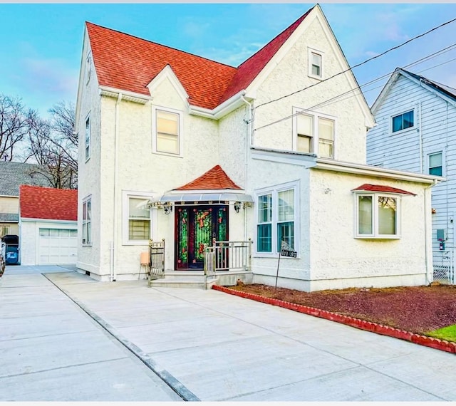111-37 197th St, Saint Albans, NY 11412 - view of front of house featuring a shingled roof, an outdoor structure, and stucco siding