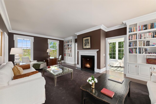 living room featuring ornamental molding, a fireplace with flush hearth, built in features, and a wealth of natural light