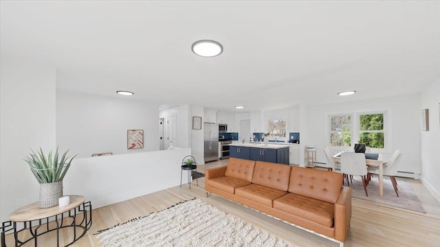 living room with recessed lighting, light wood-style floors, baseboards, and baseboard heating
