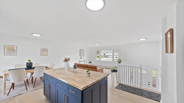 kitchen featuring blue cabinetry, recessed lighting, light wood-style floors, and wooden counters