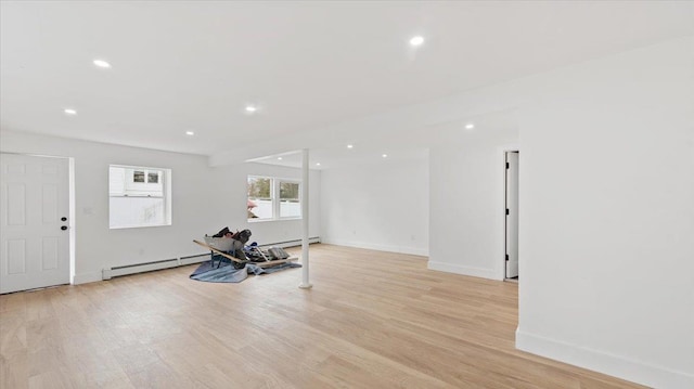 workout area featuring a baseboard heating unit, recessed lighting, and light wood-type flooring