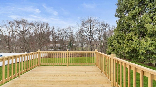 wooden deck featuring a lawn