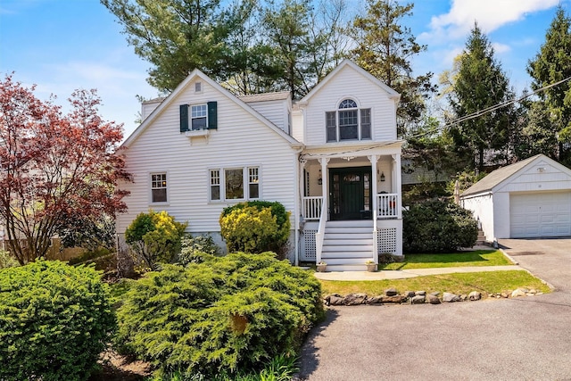 view of front of home featuring a garage, covered porch, an outdoor structure, and driveway