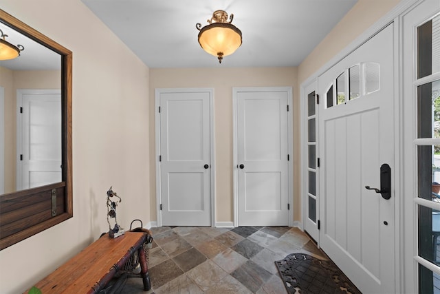 interior space featuring stone tile flooring and baseboards