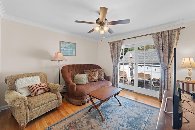 living area with crown molding, a ceiling fan, and hardwood / wood-style flooring
