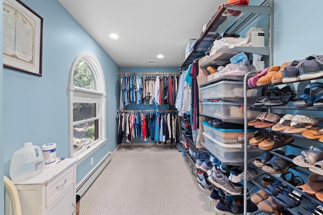 spacious closet featuring a baseboard radiator and carpet