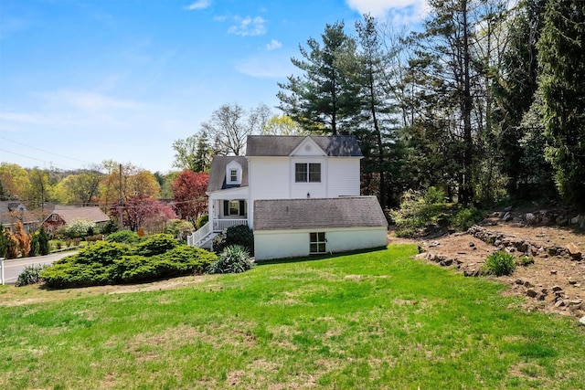 view of property exterior with stairs and a yard