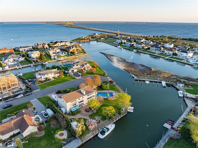 aerial view at dusk with a residential view and a water view