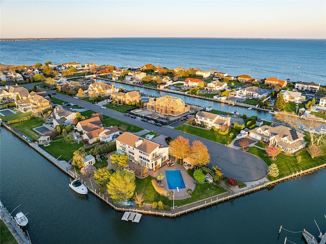 aerial view at dusk with a residential view and a water view