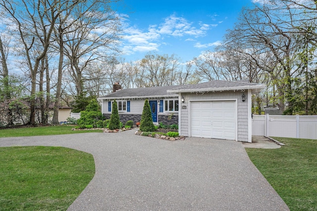 single story home featuring a front lawn, driveway, a chimney, fence, and an attached garage