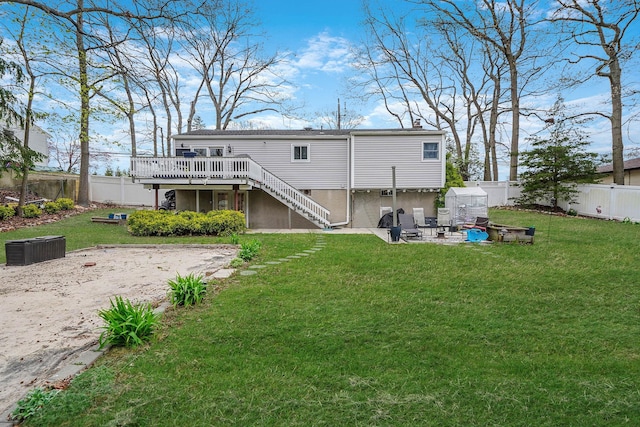 rear view of property featuring a fenced backyard, stairway, a deck, and a lawn