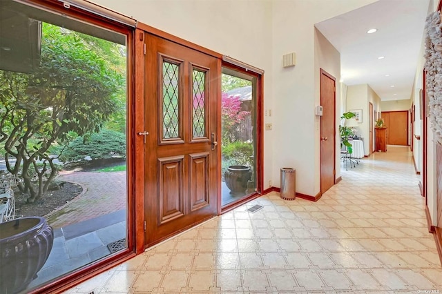 foyer with visible vents, baseboards, and light floors