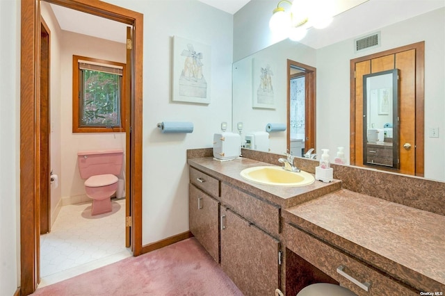 bathroom featuring visible vents, toilet, vanity, and baseboards