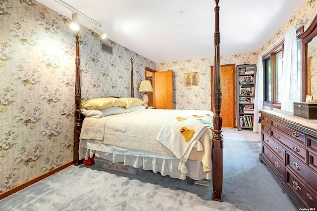 bedroom featuring visible vents, baseboards, carpet floors, and wallpapered walls