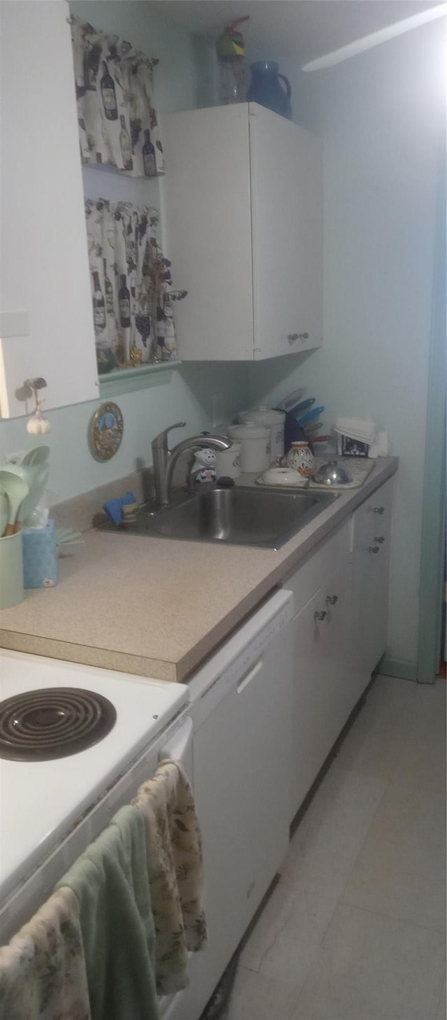kitchen featuring light countertops, white cabinetry, a sink, and white appliances