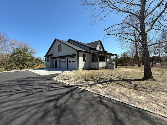 view of side of property with a garage and driveway
