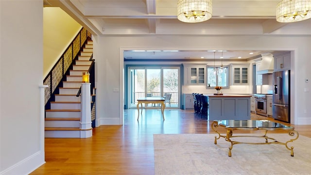 interior space with a chandelier, light wood-style floors, and baseboards
