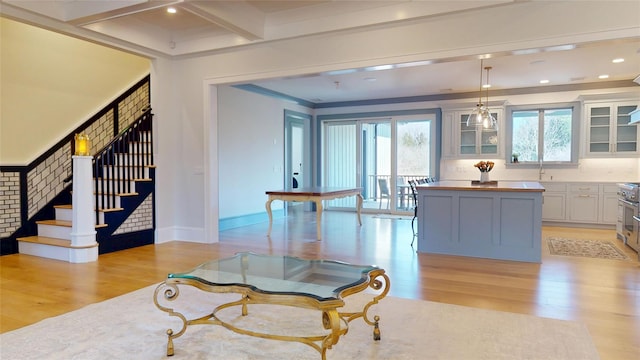 interior space with beam ceiling, light wood finished floors, recessed lighting, and stairs