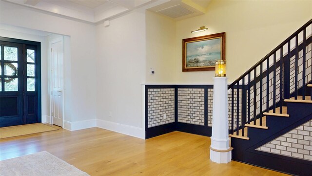 entrance foyer with stairway, visible vents, and wood finished floors