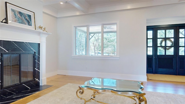 living room featuring wood finished floors, beamed ceiling, and a wealth of natural light