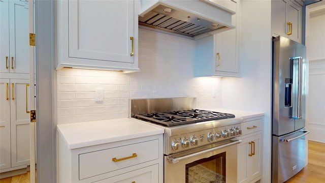 kitchen featuring custom exhaust hood, high quality appliances, light countertops, and backsplash