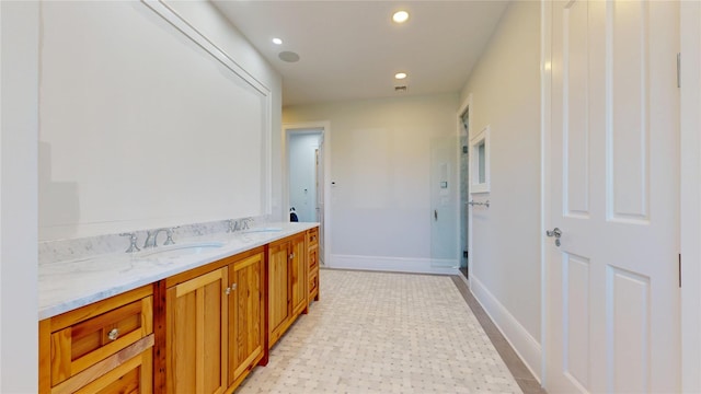 bathroom featuring double vanity, a sink, baseboards, and recessed lighting