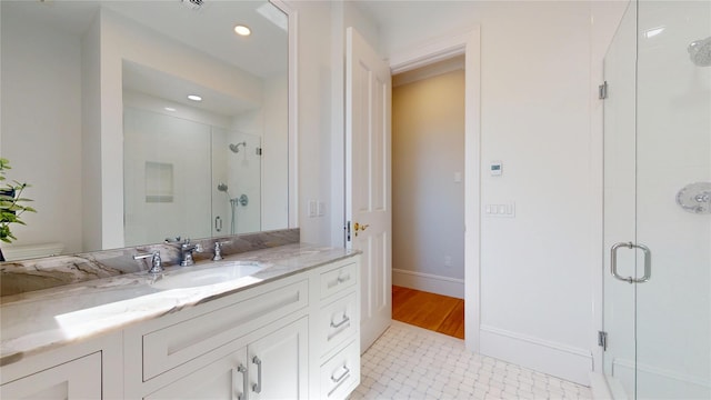 full bath featuring baseboards, toilet, recessed lighting, vanity, and a stall shower
