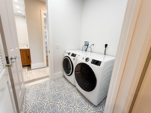 washroom featuring baseboards, light tile patterned floors, washer and clothes dryer, and laundry area