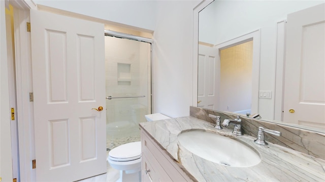 bathroom with a shower stall, vanity, and toilet