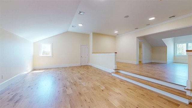 bonus room with light wood-style floors, visible vents, and vaulted ceiling