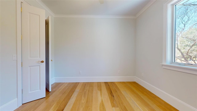 unfurnished room featuring light wood finished floors, baseboards, and ornamental molding