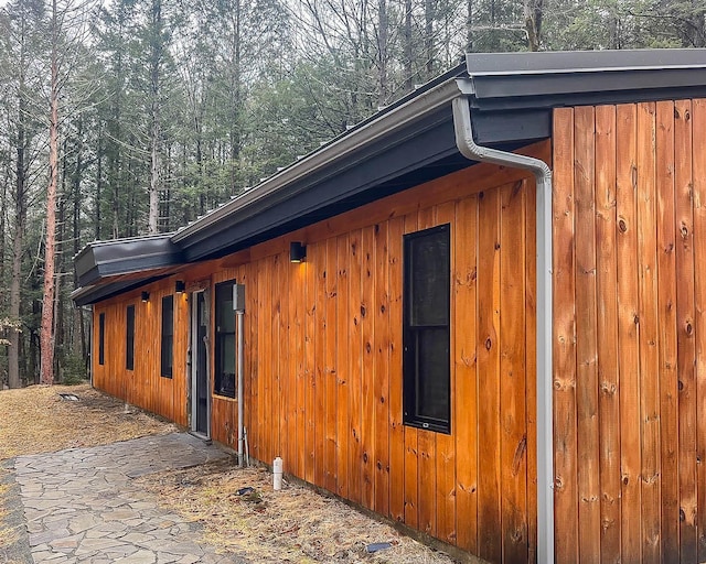 view of side of property with board and batten siding and a view of trees